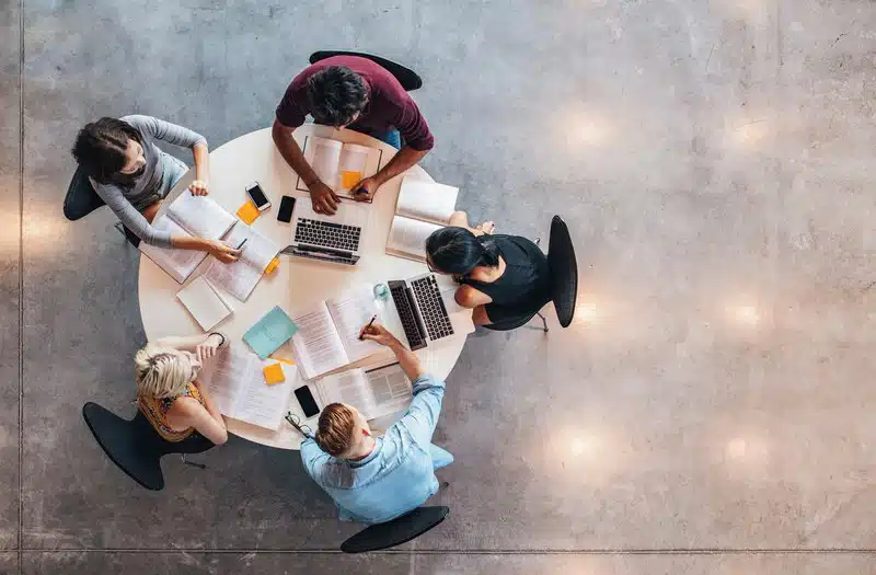 Grupo de personas que trabajan mostrando cohesión de trabajo en equipo