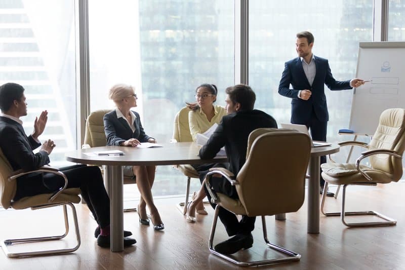 A manager explaining project to his team on a whiteboard