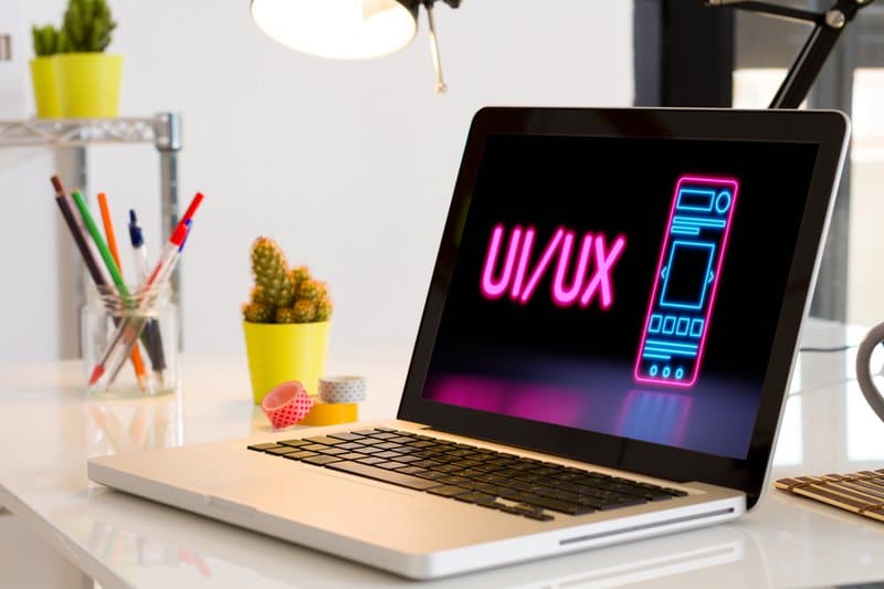 Computador na mesa com gráfico UI/UX.