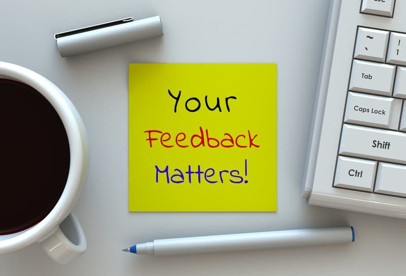 Your Feedback Matters, mensaje en papel de notas, computadora y café en la mesa