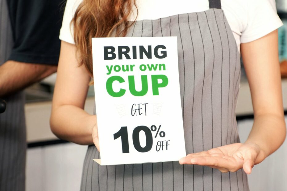 Bring your own cup get discount, Close up of waitress holding zero waste promotion poster