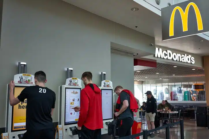 People standing near the self service kiosk of McDonald's 