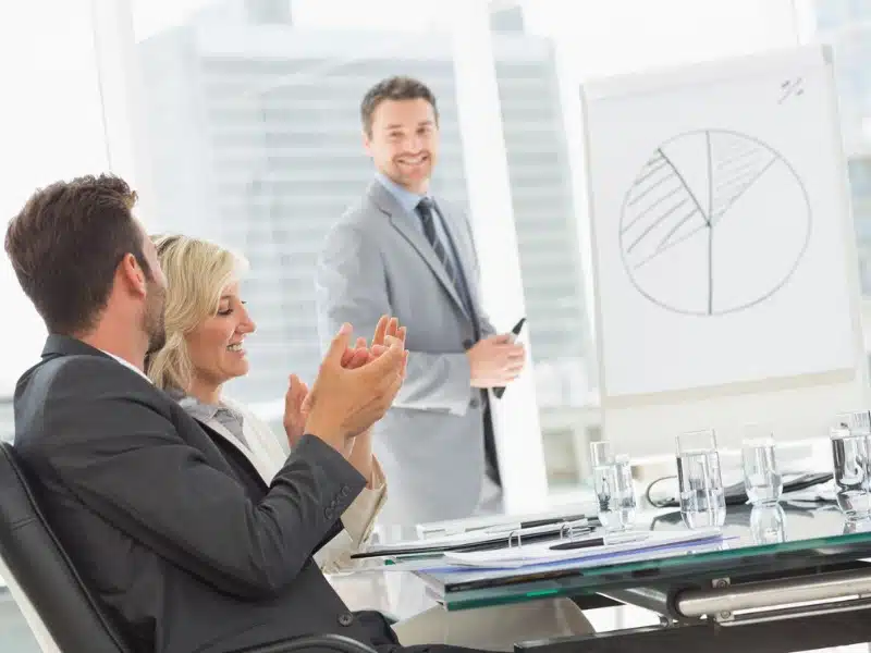 A Junior Project Manager using a whiteboard to present to his teammates