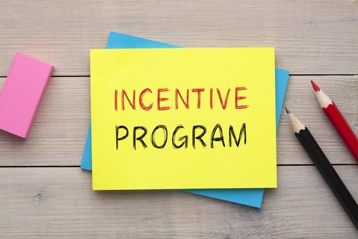 Programa de incentivos escrito en una nota adhesiva