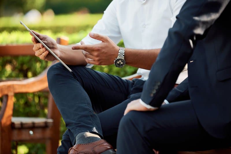 Two men talking with an iPad