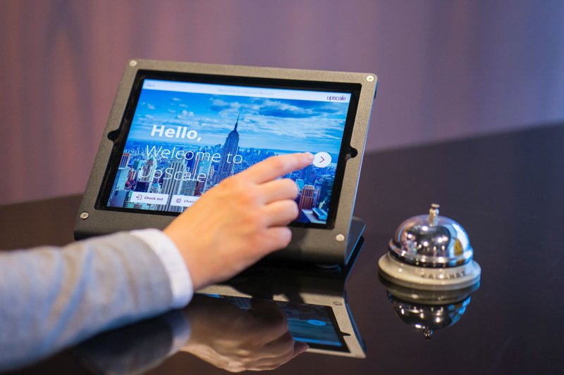 A person clicking on a tablet with a “Welcome” written on screen